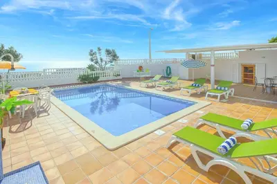 a swimming pool on a patio with chairs and a table at Villa Brigida in Albufeira
