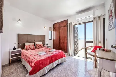 a bedroom with a bed with a red bedspread at Villa Severino in Albufeira