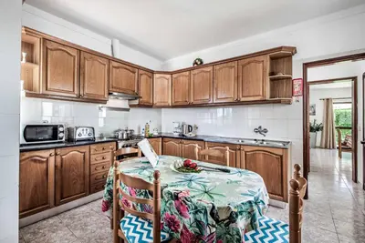 a kitchen with wooden cabinets and a table at Villa Severino in Albufeira