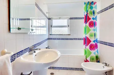 a bathroom with a sink and a mirror and a tub at Villa Coelha in Albufeira
