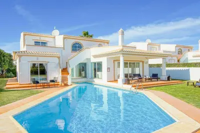 a villa with a swimming pool in front of a house at Villa Ceylon in Albufeira