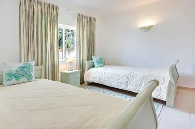 a bedroom with two beds and a window at Villa Ceylon in Albufeira