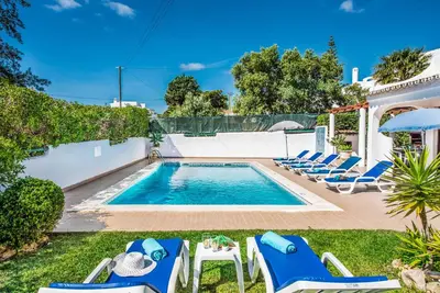 a swimming pool with blue chairs and a swimming poolvisorvisor at Villa Miramar in Albufeira