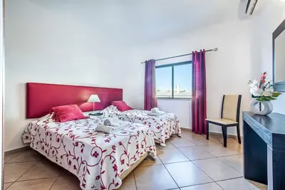 a bedroom with two beds and a window at Villa Lourenco in Albufeira