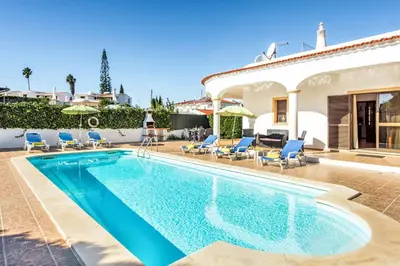 a swimming pool in front of a villa at Villa Lourenco in Albufeira