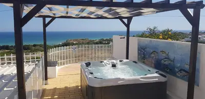 a hot tub on a balcony with a view of the ocean at Villa Albuar in Albufeira