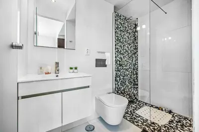 a white bathroom with a toilet and a shower at Casa dos Amigos in Albufeira