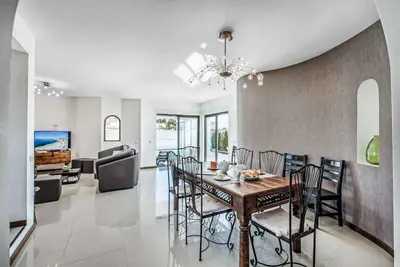 a dining room and living room with a table and chairs at Casa dos Amigos in Albufeira