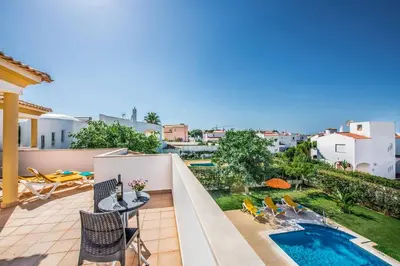 a balcony with a pool and a table and chairs at Villa Altair in Albufeira