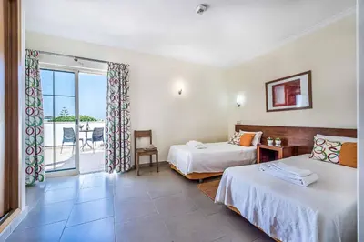 a hotel room with two beds and a balcony at Villa Altair in Albufeira