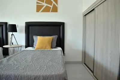 a kitchen with white cabinets and a sink at Rua José Afonso in Albufeira