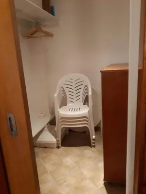 a white plastic chair sitting in a room at Casa Boneca - Aldeia das Açoteias in Albufeira