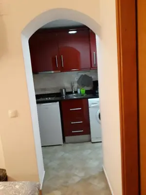 a kitchen with red cabinets and white appliances at Casa Boneca - Aldeia das Açoteias in Albufeira