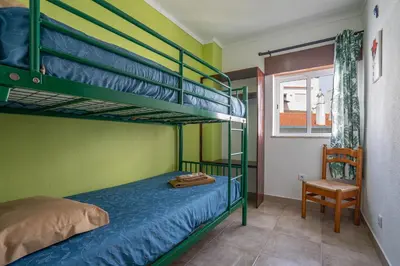 a bedroom with two bunk beds and a chair at Apartamentos Old Town by Umbral in Albufeira