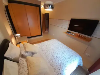 a bedroom with a bed and a flat screen tv at SunHouse Room in Albufeira