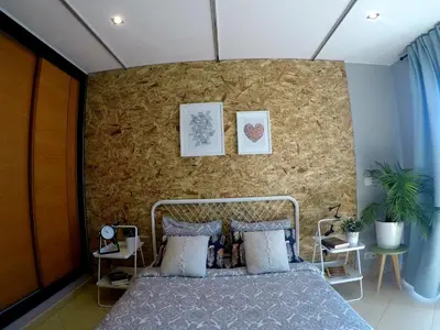 a bedroom with a bed and a brick wall at SunHouse Room in Albufeira