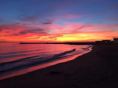 a sunset on a beach with the ocean at CASA JOY Vilamoura apartment in Vilamoura