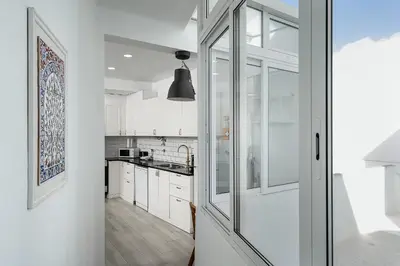 a kitchen with white cabinets and a sliding glass door at Casa Mina in Faro