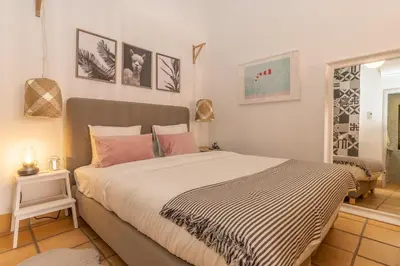 a bedroom with a large bed with pink pillows at FARO DOWNTOWN STUDIOS in Faro
