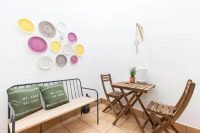 a room with a bench and a table with plates on the wall at FARO DOWNTOWN STUDIOS in Faro