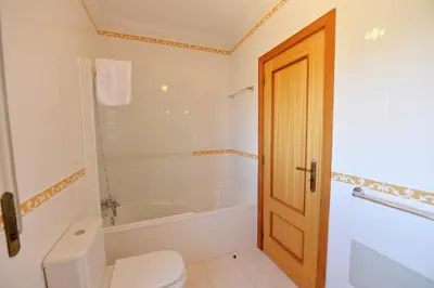 a bathroom with a toilet and a bath tub at TownHouse next to Falésia Beach in Albufeira