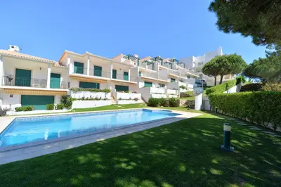 a swimming pool in front of a building at TownHouse next to Falésia Beach in Albufeira