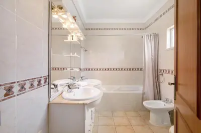 a bathroom with two sinks and a toilet and a tub at Yara Beach Apartments with Terrace in Albufeira
