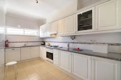 a kitchen with white cabinets and a stove top oven at Yara Beach Apartments with Terrace in Albufeira