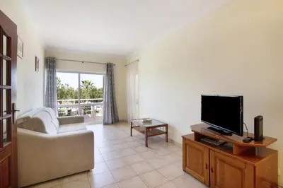 a living room with a couch and a television at Yara Beach Apartments with Terrace in Albufeira