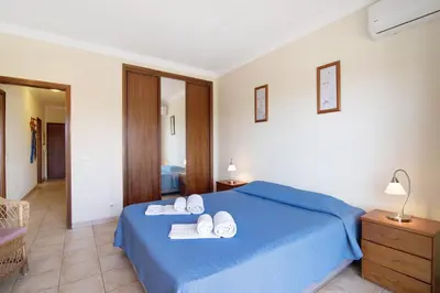 a bedroom with a blue bed with towels on it at Yara Beach Apartments with Terrace in Albufeira