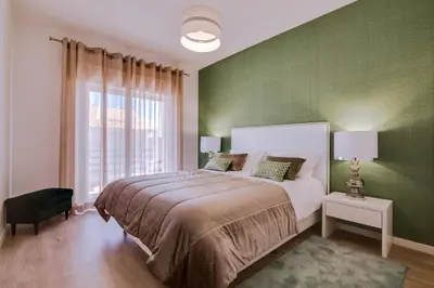 a bedroom with a large bed and a green wall at Ella - Fantastic apartment - Vilamoura in Vilamoura