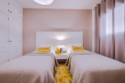 a bedroom with two beds and a table with yellow pillows at Ella - Fantastic apartment - Vilamoura in Vilamoura