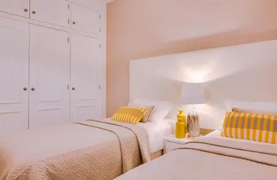 two beds in a room with white walls and yellow pillows at Ella - Fantastic apartment - Vilamoura in Vilamoura