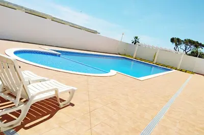 a swimming pool on a patio with a white chair at Martin House - Montenegro - FARO - ALGARVE in Faro