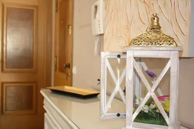 a kitchen counter with a lantern with flowers in it at Rising Sun Apartment in Albufeira