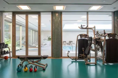 a gym with cardio equipment in a room with windows at EPIC SANA Algarve Hotel in Albufeira
