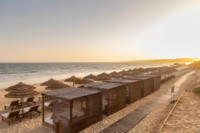 a row of umbrellas and chairs on a beach at EPIC SANA Algarve Hotel in Albufeira