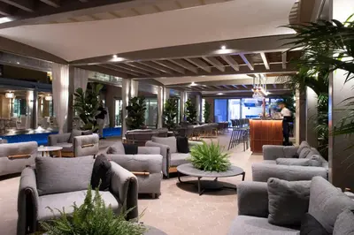 a lobby with couches and chairs and a bar at EPIC SANA Algarve Hotel in Albufeira