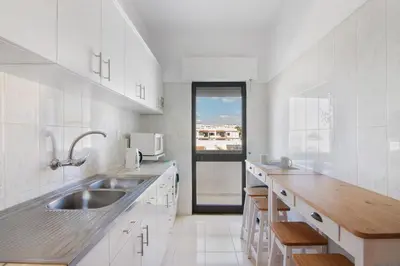 a white kitchen with a sink and a microwave at City Center Albufeira in Albufeira