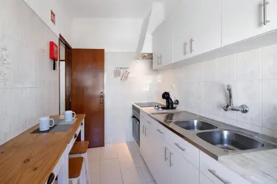 a small kitchen with a sink and a counter at City Center Albufeira in Albufeira
