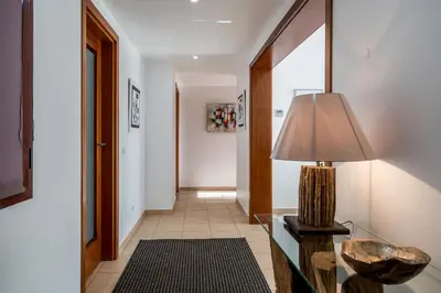 a hallway with a table with a lamp on it at Vilasol apartment by Intiholidays in Vilamoura