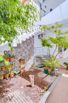 a courtyard with trees and potted plants in a building at À da Avó -The Guesthouse in Faro