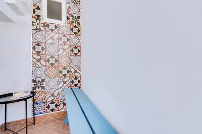 a staircase in a room with a patterned wall at À da Avó -The Guesthouse in Faro