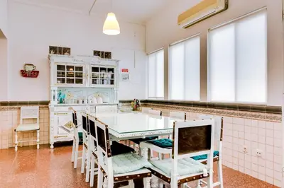a kitchen with a table and chairs and windows at À da Avó -The Guesthouse in Faro