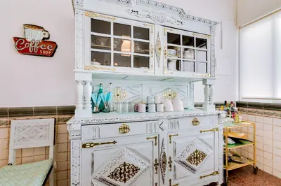 a white cabinet in a kitchen with a shelf at À da Avó -The Guesthouse in Faro