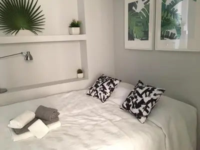 a white bed with two pillows and towels on it at Vilamoura Apartment in Quarteira
