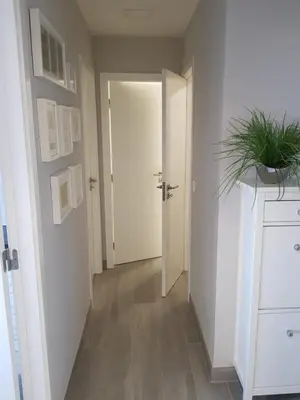a hallway with a white door and a potted plant at Vilamoura Apartment in Quarteira