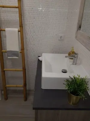 a bathroom with a sink with a plant on the counter at Vilamoura Apartment in Quarteira