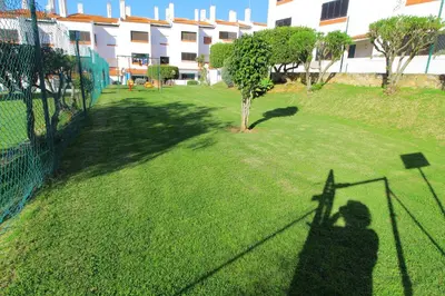 a shadow of a person standing next to a fence at Apartamento das Oliveiras in Albufeira