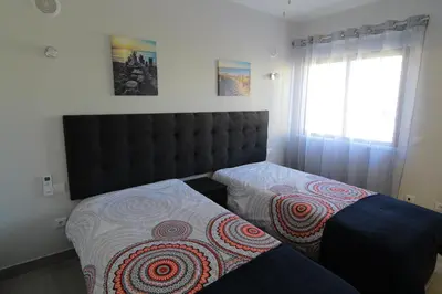 a bedroom with two beds and a window at Apartamento das Oliveiras in Albufeira